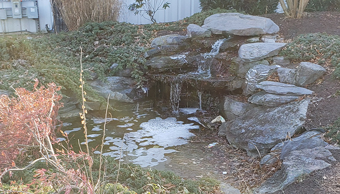 man-made waterfall with water flowing over rocks